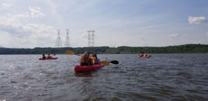 Students in a kayak on the Hudson River. The 2022 River Ecology Class paddles on the Hudson River after examining water chemistry and aquatic plants.