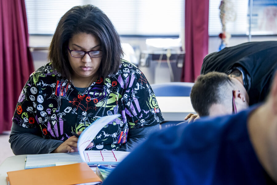 Nursing student seated while flipping through text book