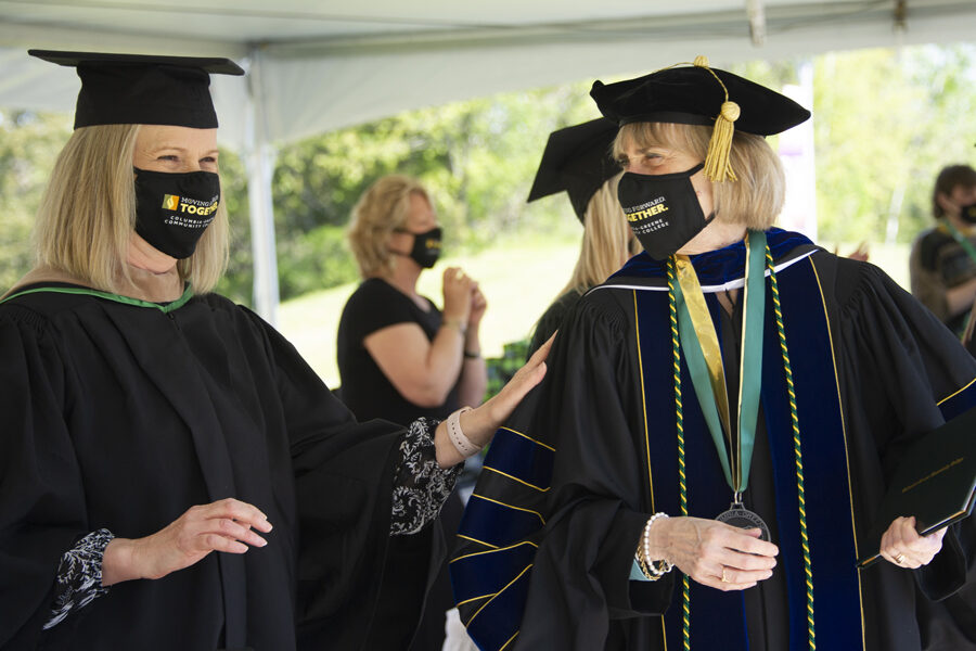 Graduation officiants wearing masks, caps, and gowns during COVID graduation
