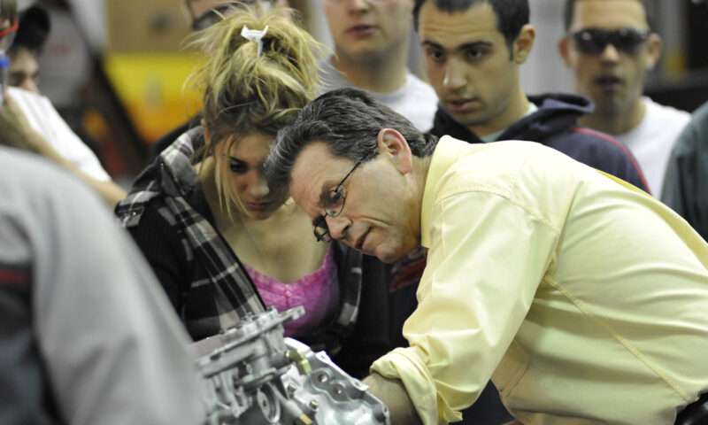 Students in the auto tech lab listen to a professor.