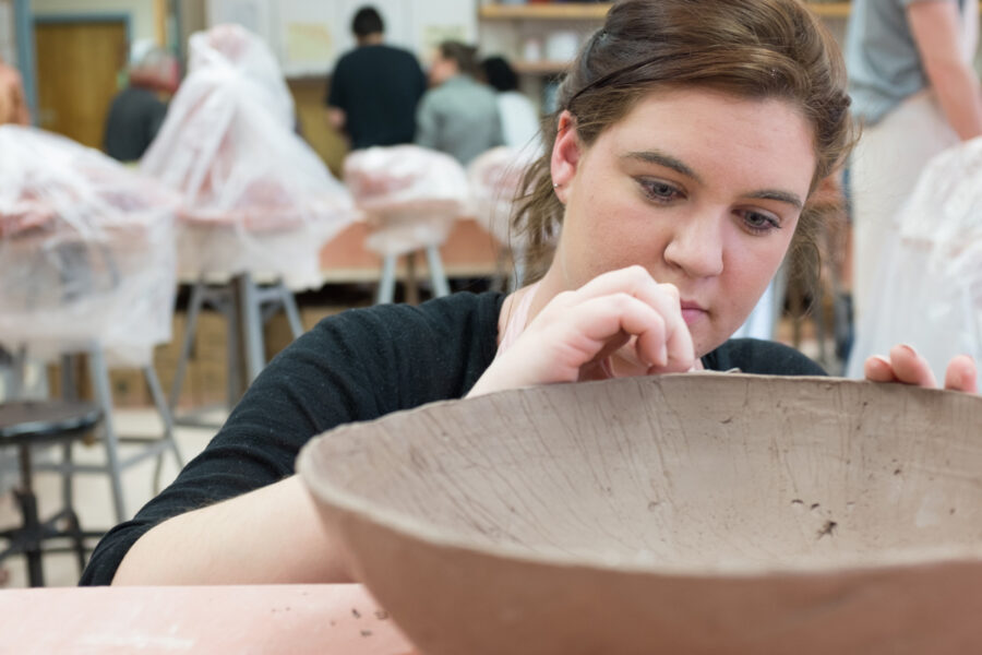 Female student working on a large bowl in the ceramics lab