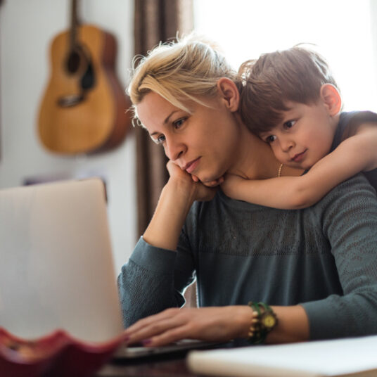 Student studying remotely with young son