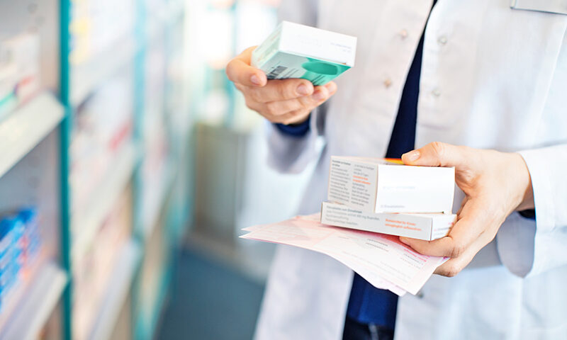 Pharmacist holding prescriptions