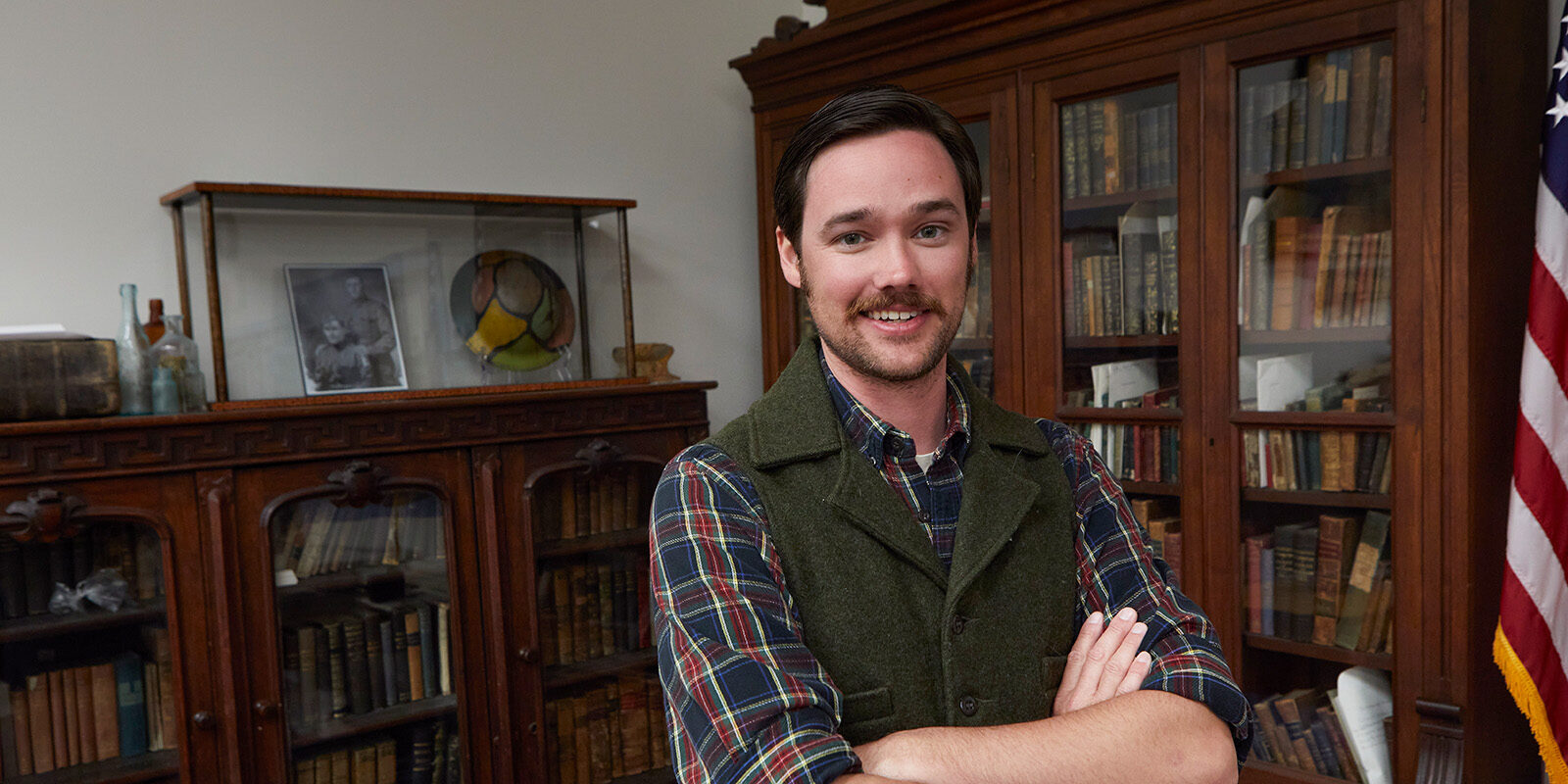 Jonathan Palmer, Greene County Historian, Vedder Research Library standing in front of antique bookshelves