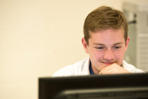 Young, Caucasian male working on computer